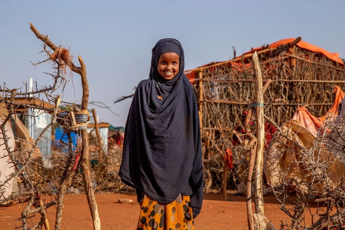 At an IDP camp in Somolia, a girl smiles for a photo.