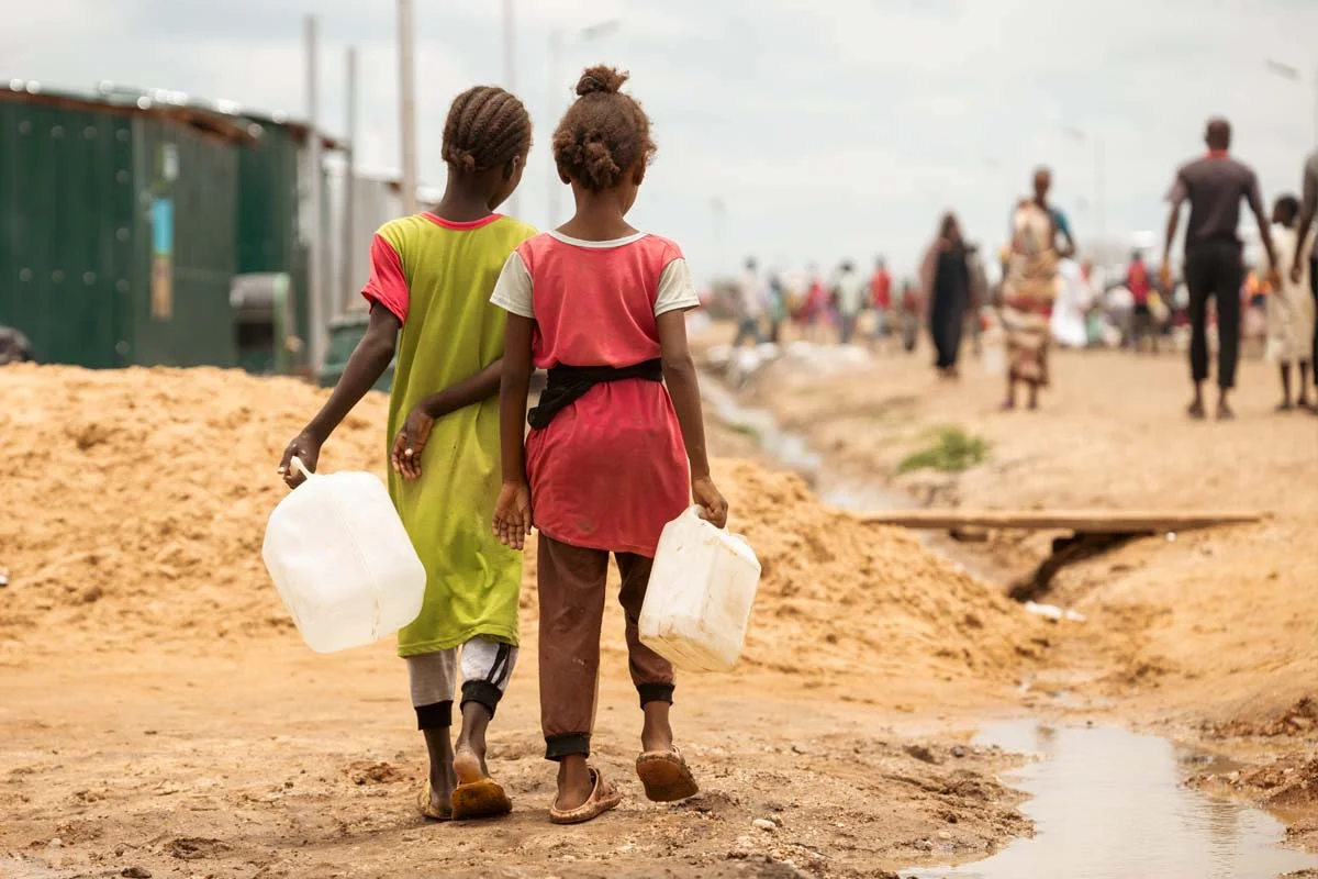 Two girls collect water in renk