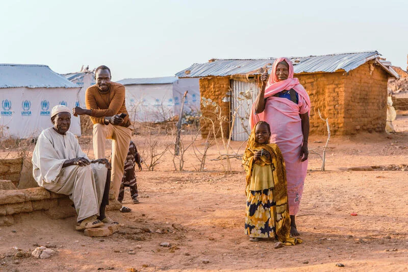 Halima, right, smiles with her family at the refugee camp in eastern Chad. Halima works as a cook in the camp and provides food daily for children who live there.  