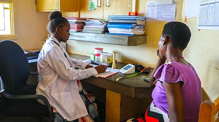 Priscilla, a former sponsored child, is carrying out Antenatal care at Kasambya Health Center, where she was born.