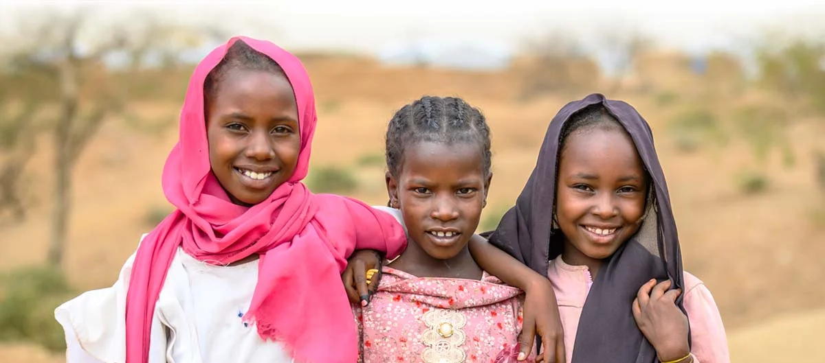 three girls stand together with hope
