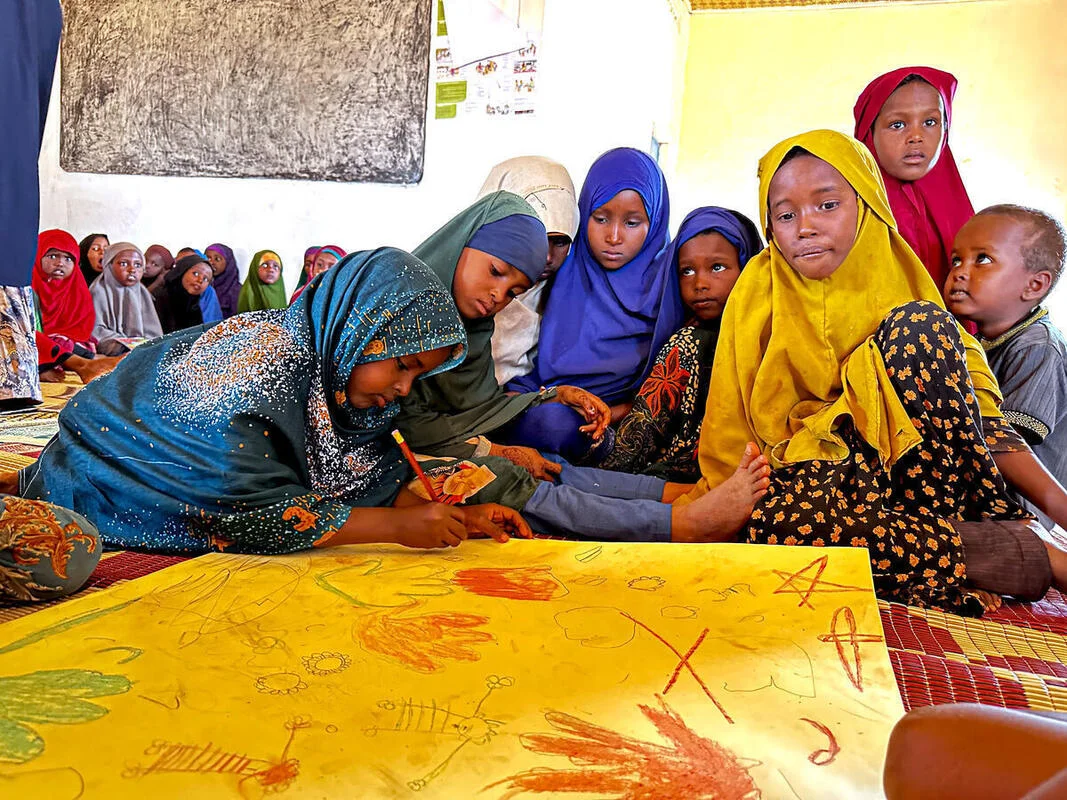 Children play and color in their classroom in an internal displacement camp in Somalia 