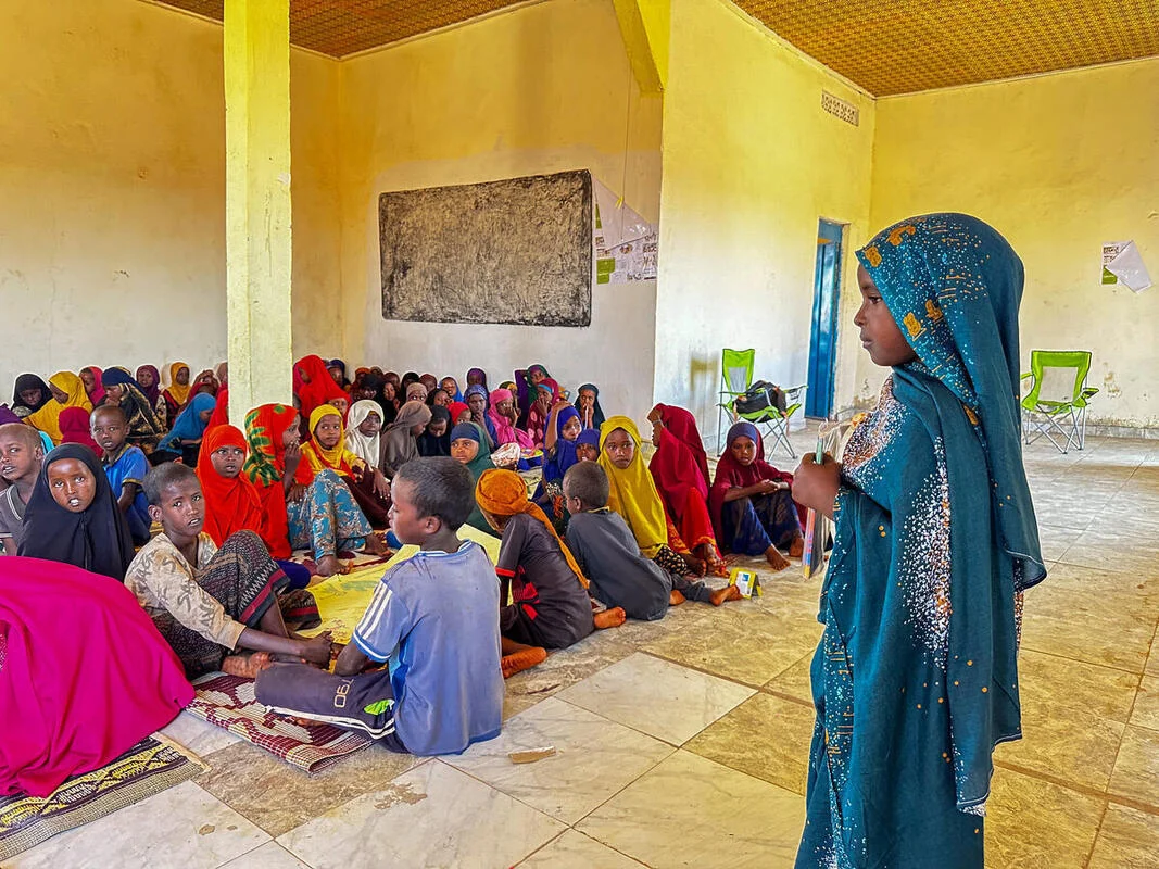 A young girl shares what she’s learned with her classmates. 