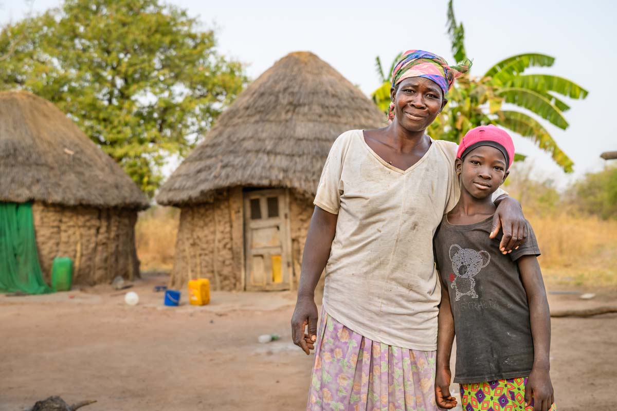 woman and child smile due to to the support provided to their village