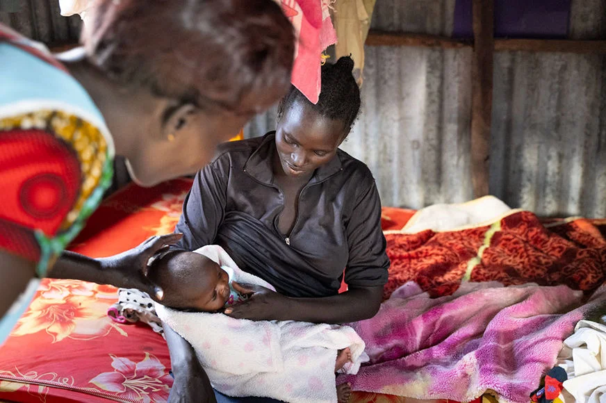 A woman holds a baby.