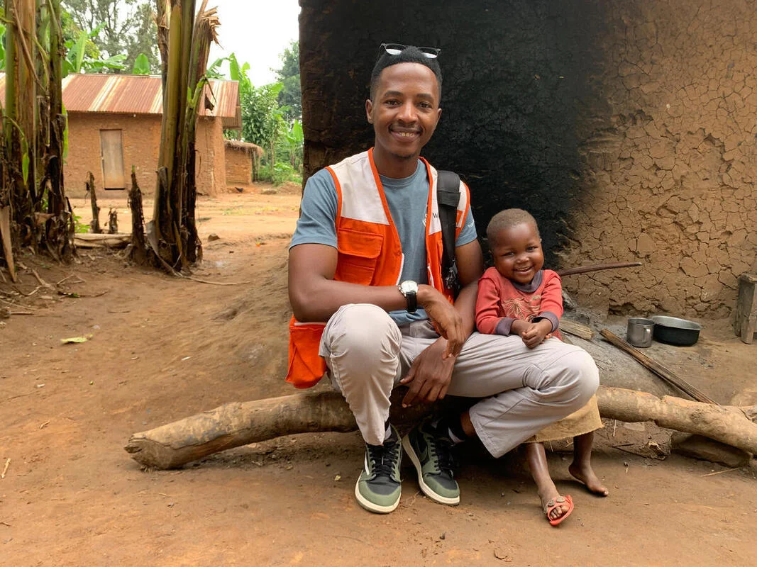 A World Vision employee and a young child in the Democratic Republic of Congo smile for a picture. 