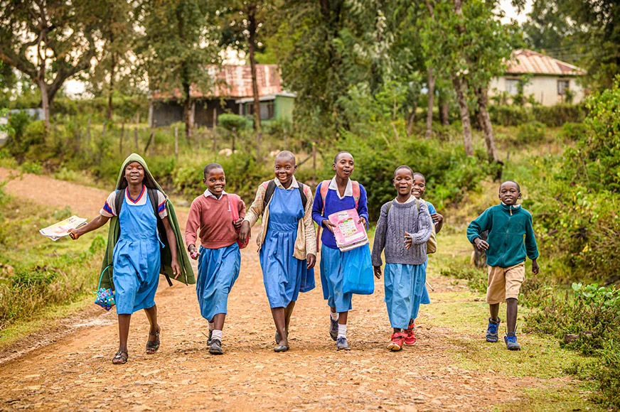 A group of students head home after class in Katito, a community that recently reached self-suffiency after two decades of partnership with World Vision. (Kenya, 2022)