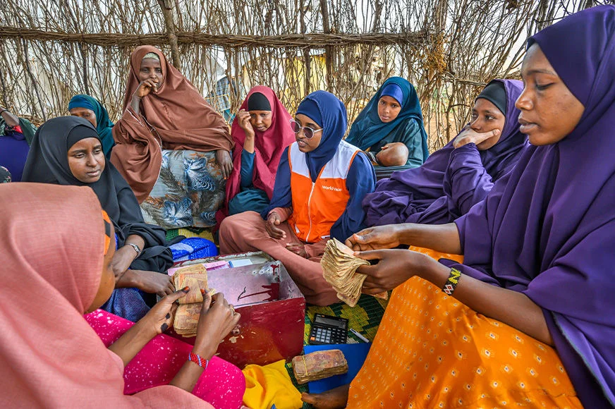 World Vision staff mentors a group of women about savings in an internally displaced persons camp in Baidoa, Somalia. (Somalia, 2023)