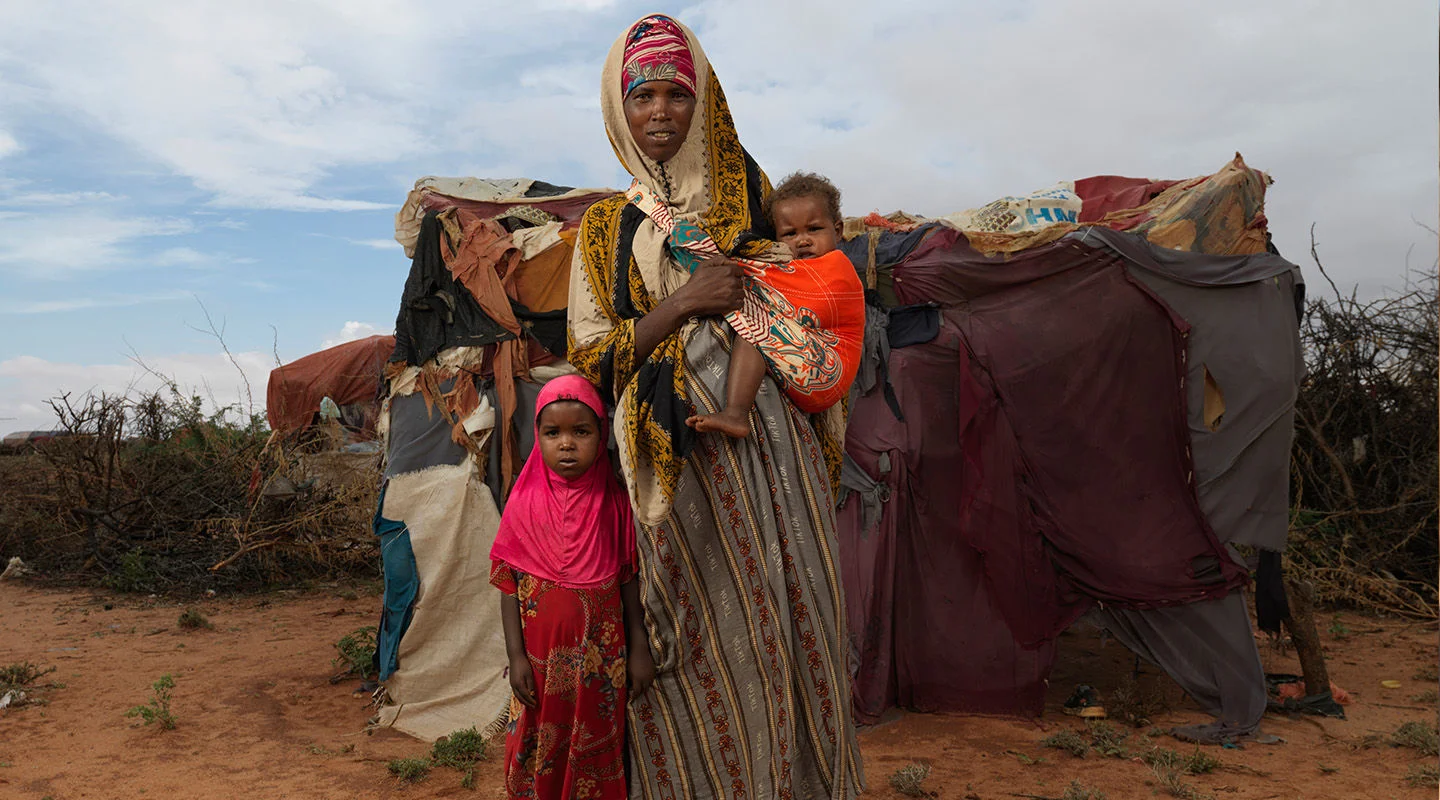 A woman with her two children near a make-shift tent in a drought-affected area in Somalia.