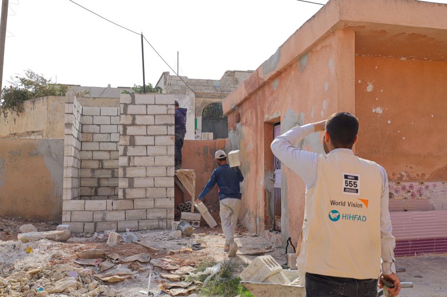 In Syria, a man wearing a World Vision vest oversees new construction being done for the schools. 