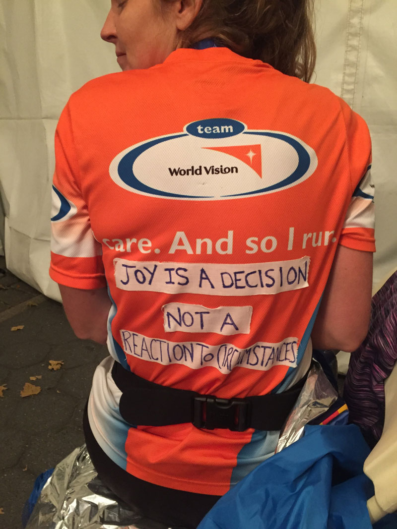 A woman runner shows off the back of her Team World Vision shirt.