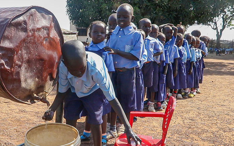 School children in South Sudan line up to wash their hands.