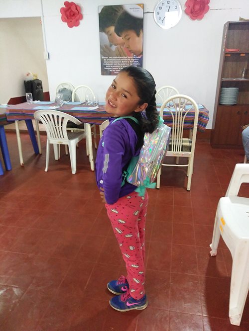 Sponsor child showing off her new backpack