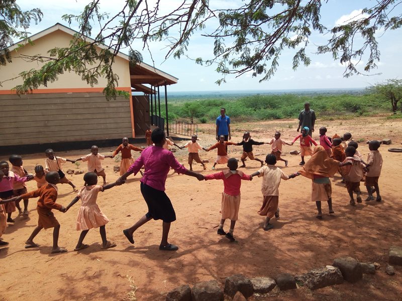 Madame Mwakesi playing with her class outside