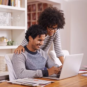 A man and woman looking at a laptop screen